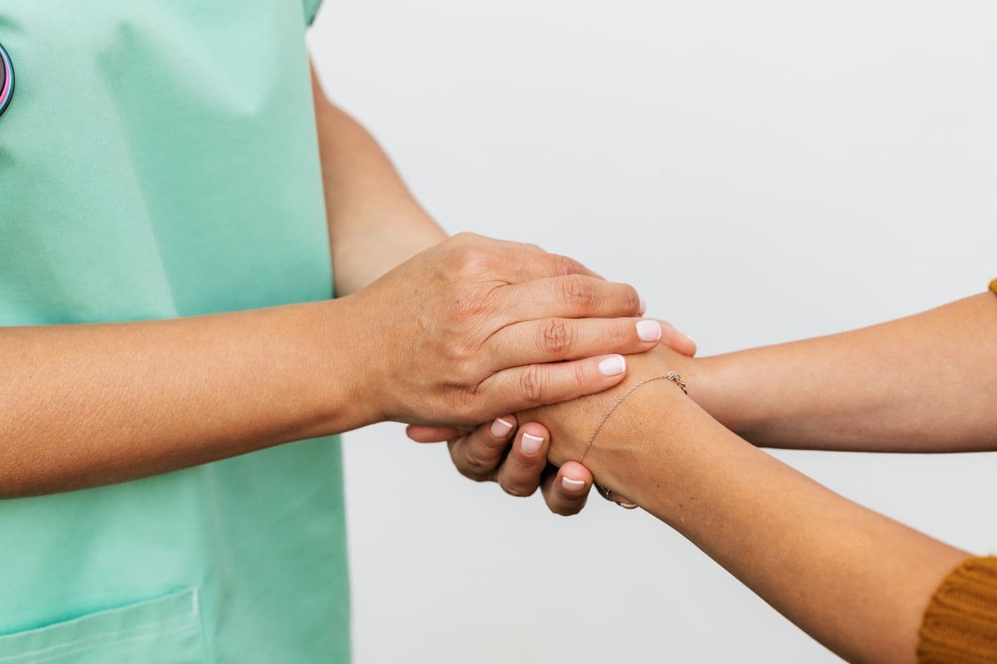 A hearing professional holding a patient's hands reassuringly