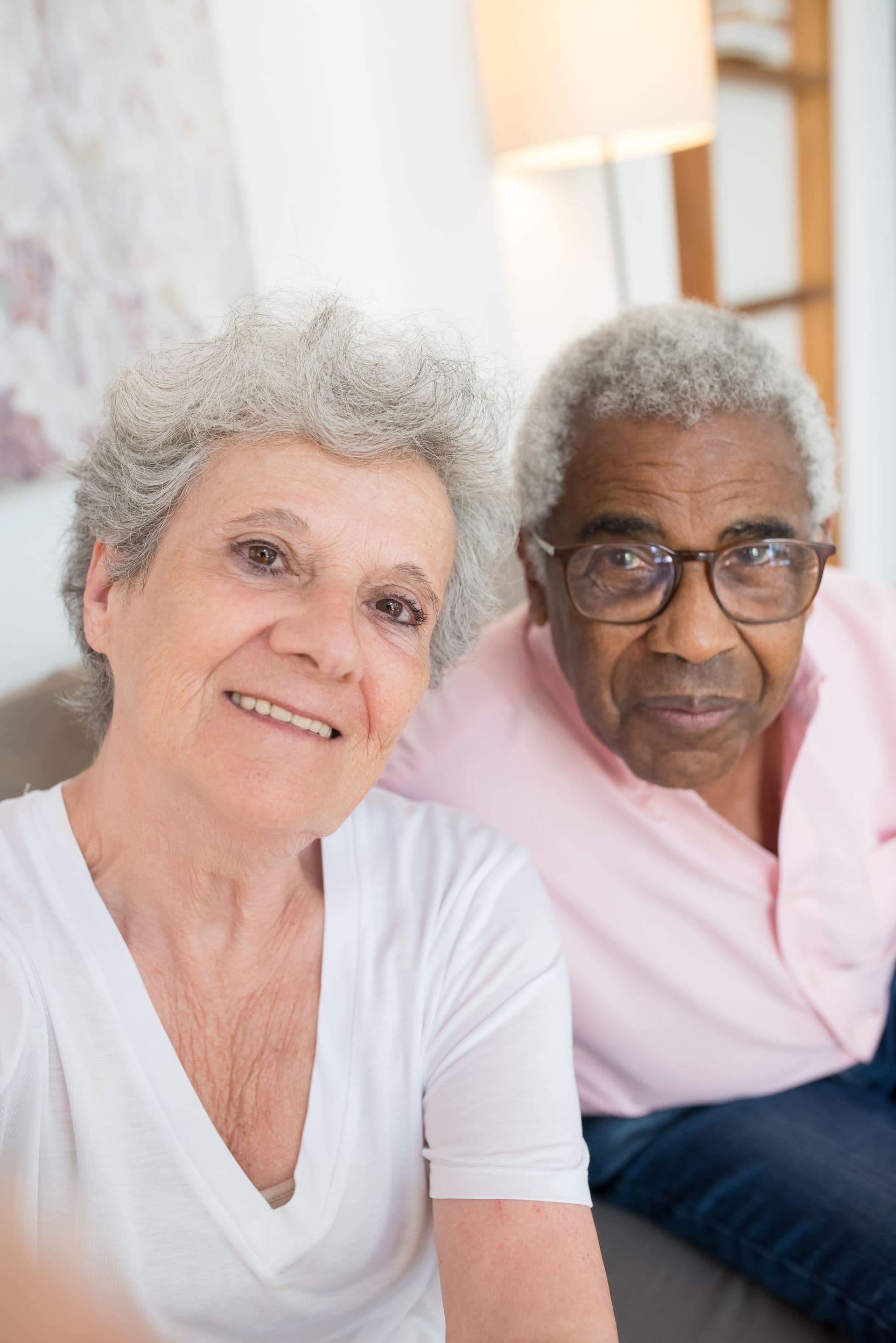 Two older adults laughing together in warm daylight