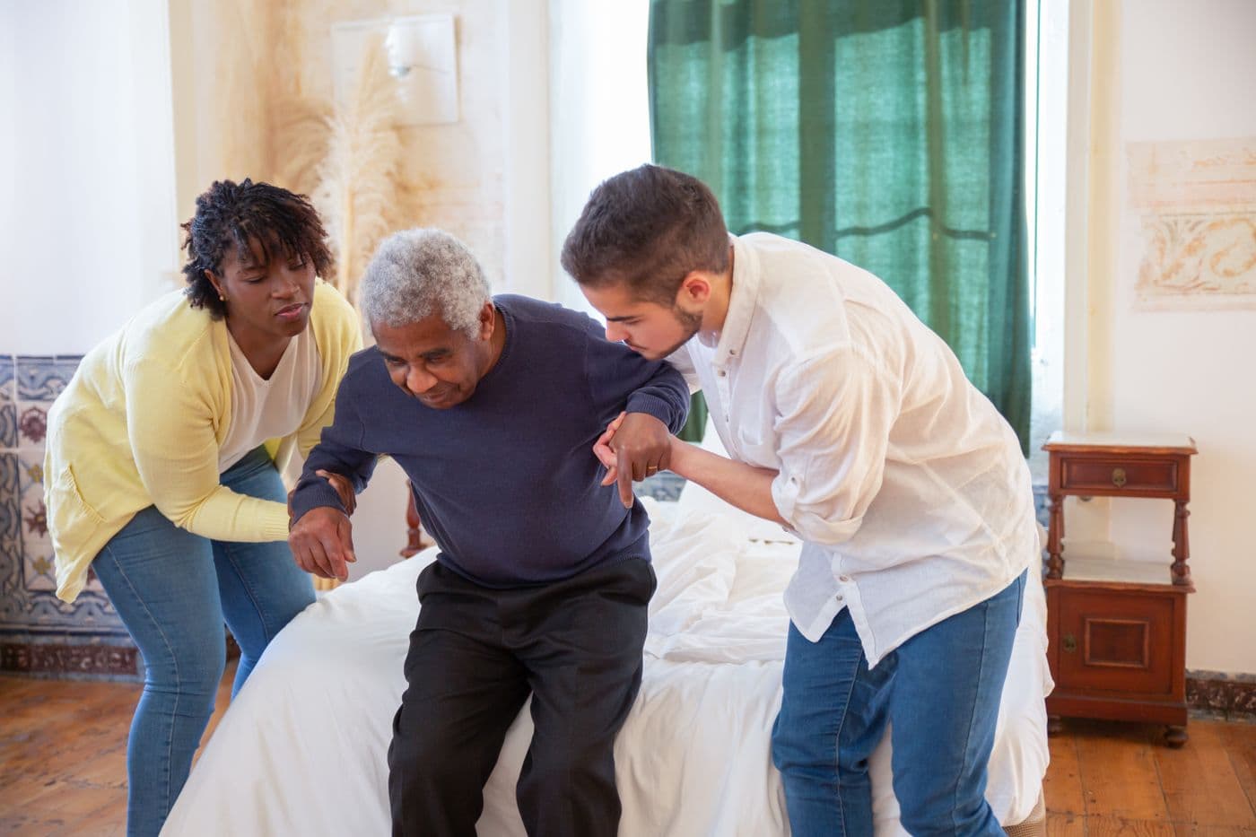 A hearing professional assisting an older patient at home