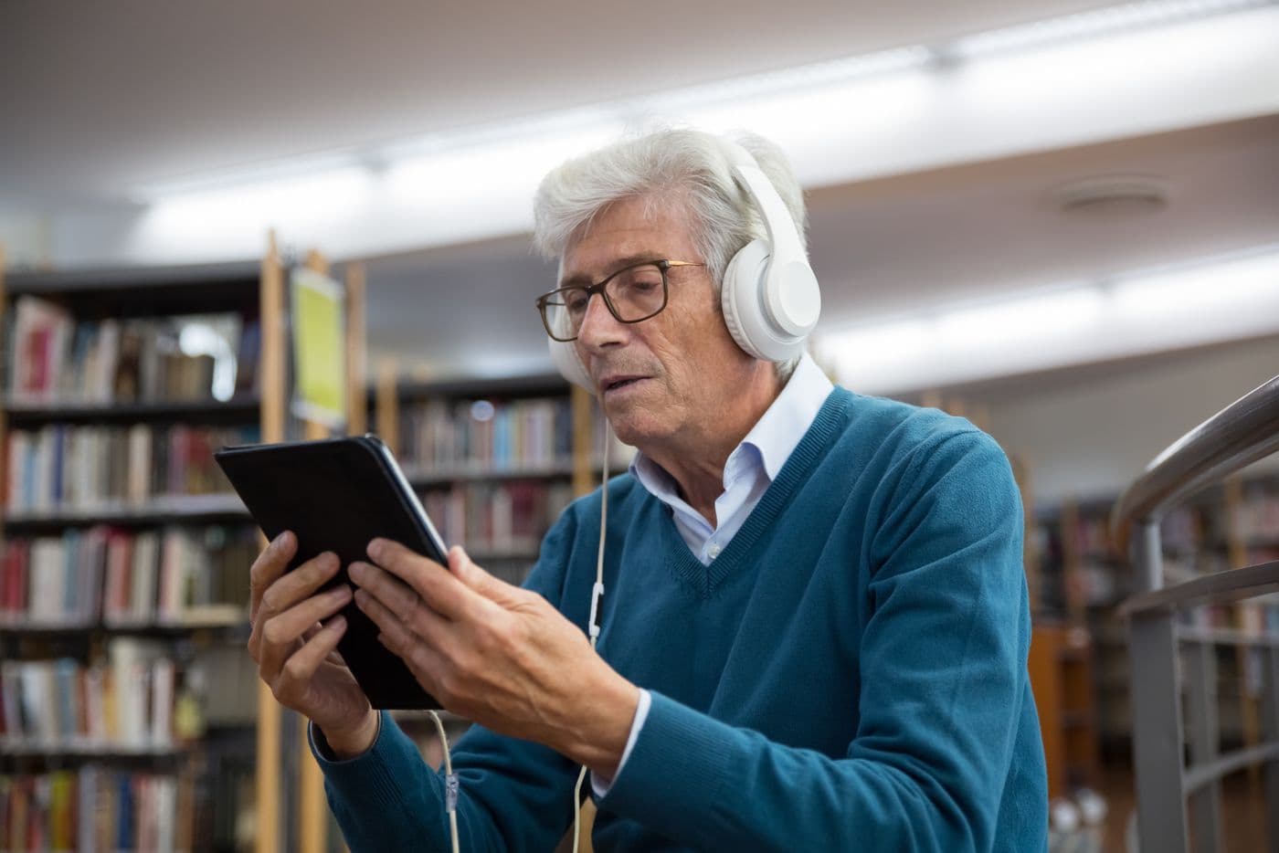 An older man listening carefully through headphones